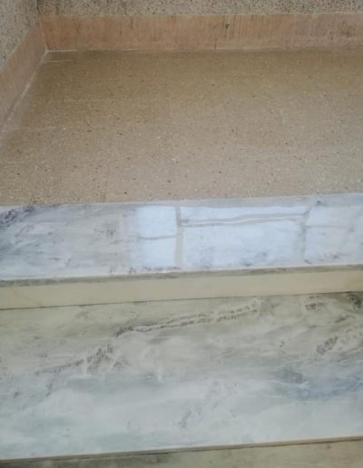 Dettaglio di scala in marmo trattata con levigatura e lucidatura da Robur Service Srl, effetto uniforme e brillante.