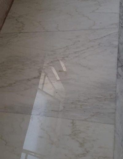Pavimento in marmo lucidato da Robur Servizi Srl in un vano scala condominiale, con effetto lucido e riflettente.
