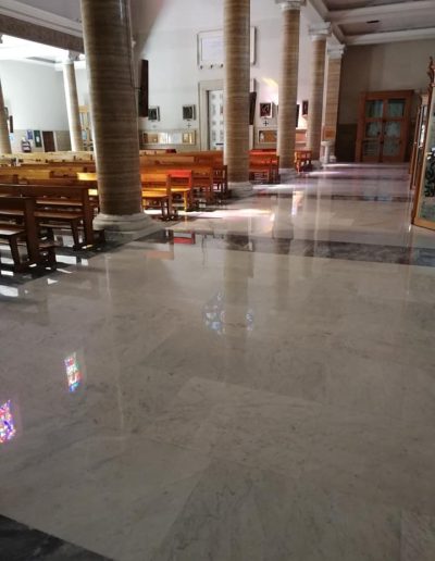 Navata laterale di una chiesa con pavimento in marmo restaurato e lucidato da Robur Servizi Srl.