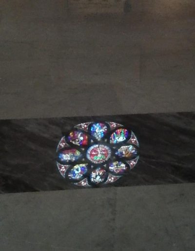 Riflesso colorato di una vetrata artistica su pavimento in marmo lucidato a specchio, intervento Robur Servizi Srl.