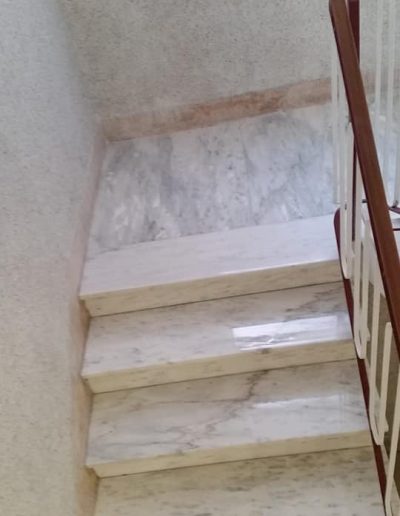 Scala condominiale in marmo pulita e lucidata da Robur Service Srl, ripristinata con un trattamento a specchio.