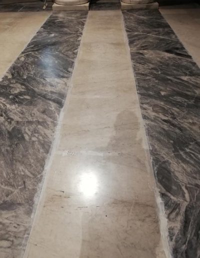 Dettaglio ravvicinato di un pavimento in marmo con fughe appena ripristinate, lavoro eseguito da Robur Servizi Srl.